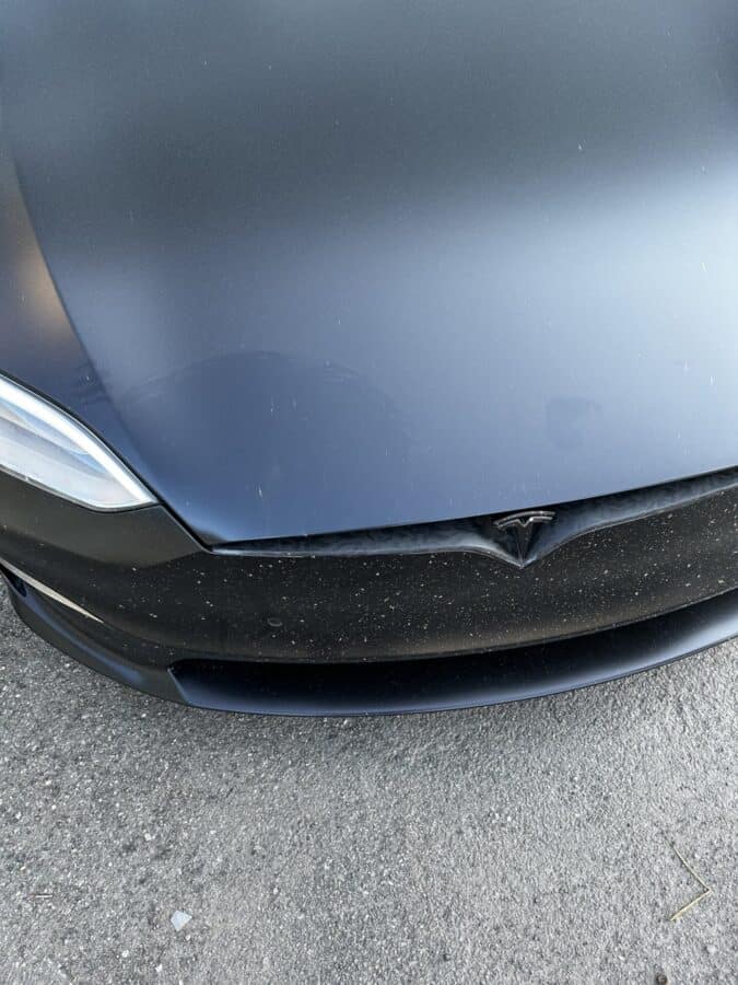 An unknown person sat on MKBHD's Tesla Model S, the hood of the electric car was bent - what is it made of?
